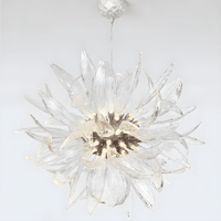 Helios sunburst chandelier displayed on a white background, highlighting sculptural glass blades and warm LED core.