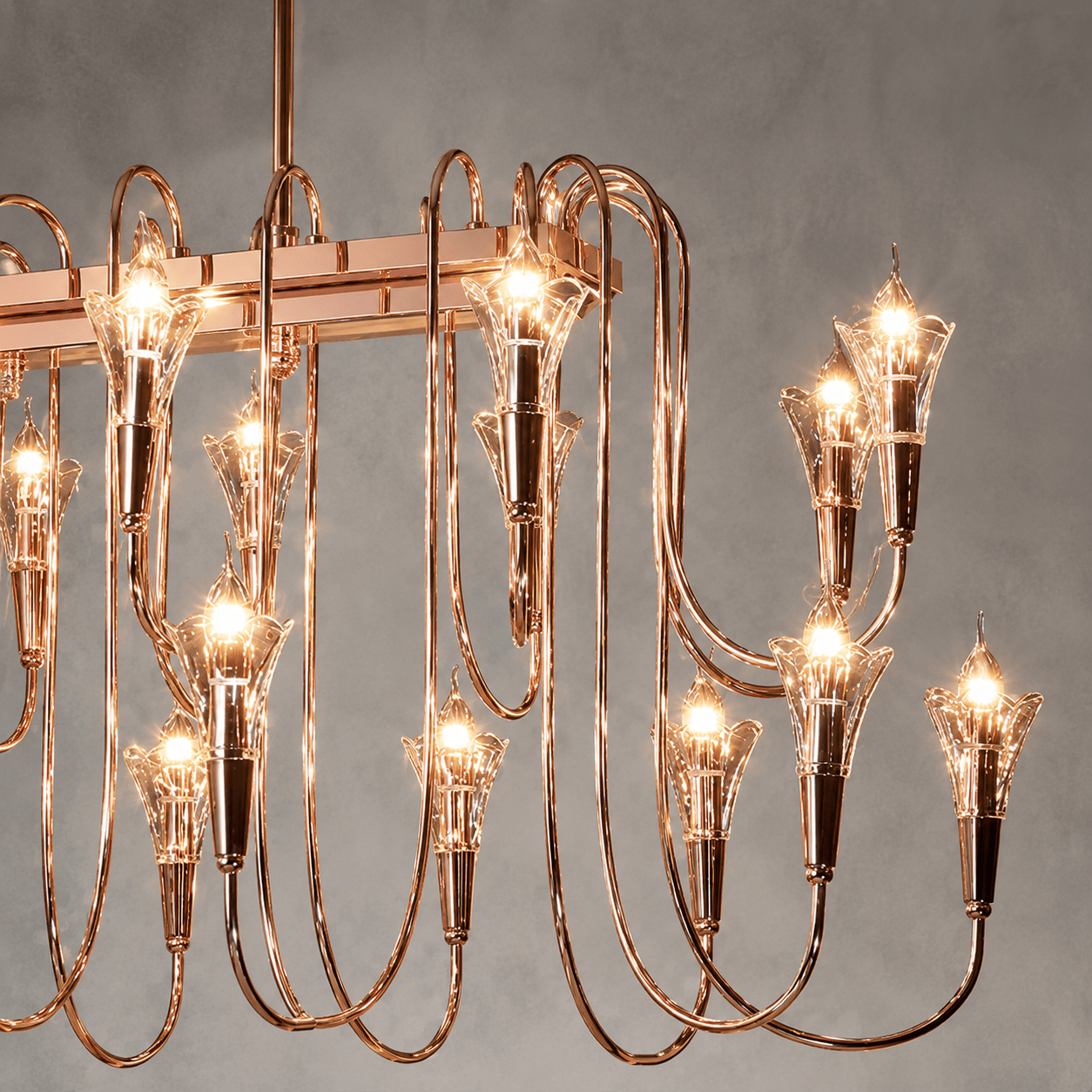 Close-up of the Hyperion Lumina rose gold linear chandelier with sculptural crystal candle-style lights