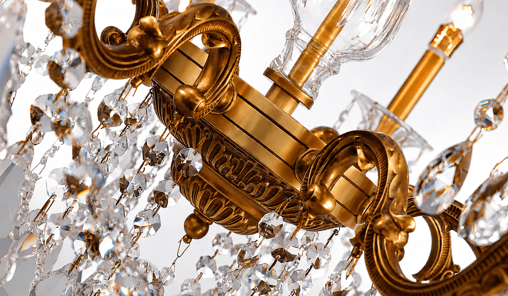 Close-up of Petite chandelier showing bronze scrollwork and crystal strands.