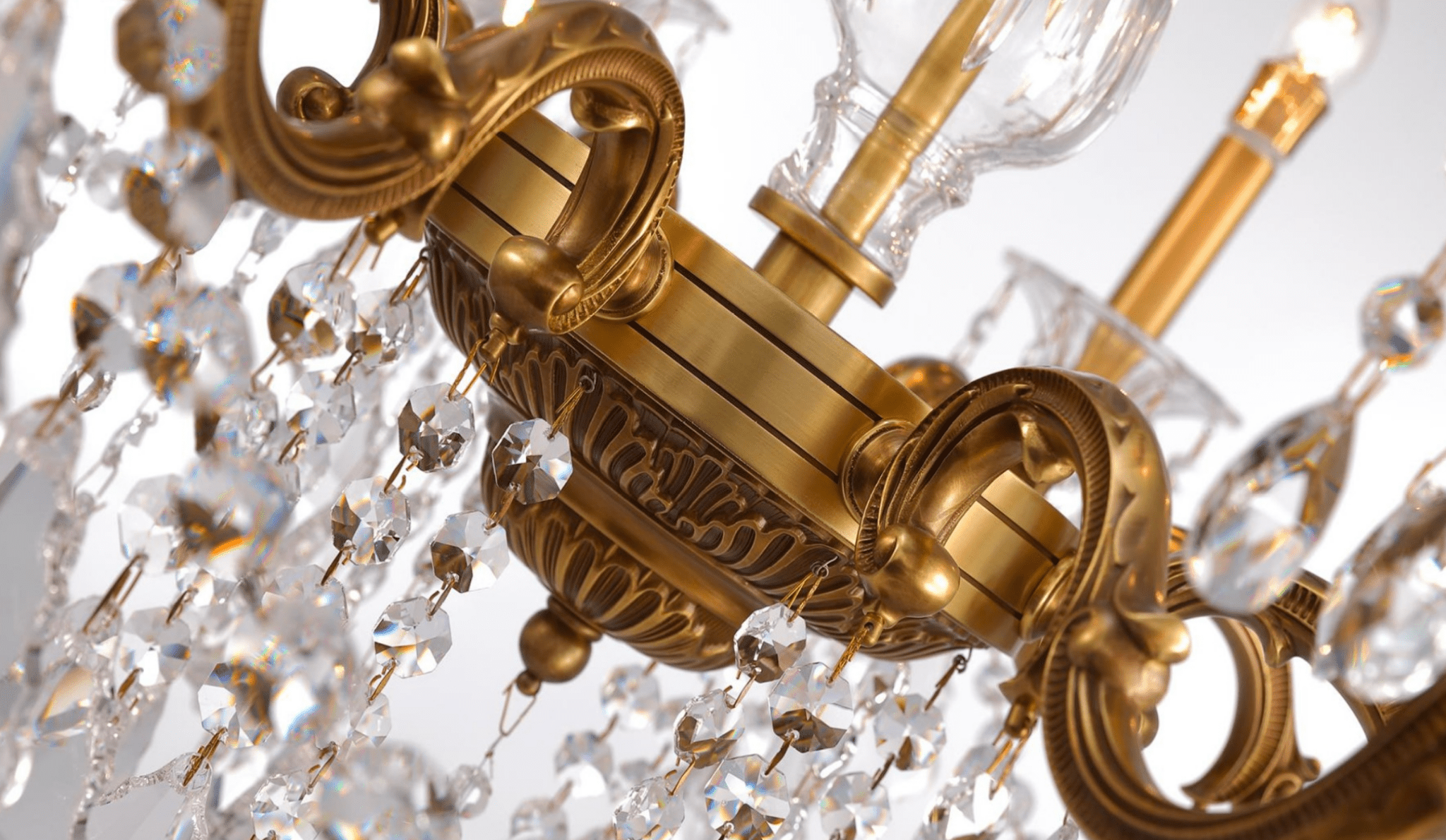 Close-up of Petite chandelier showing bronze scrollwork and crystal strands.