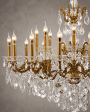 Close-up of Imperial Grace Regina crystal chandelier with bronze-gold arms and illuminated candle bulbs.