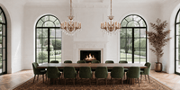 Two Shine chandeliers installed in a grand dining room with tall arched windows.