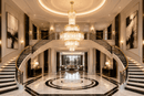 La Scala Crystal Sovrano luxury crystal chandelier in a grand double-height entrance with curved staircase