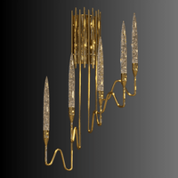 Angled view of Luce di Roma Foro gold wall sconce with sculptural arms and champagne Asfour crystal spears.