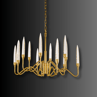 Hestia chandelier illuminated against a dark background, highlighting gold-plated frame and champagne crystal spires.