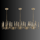 Long 218 cm Luce di Roma Vesta chandelier featuring 35 gold arms and champagne Asfour crystal spires on a dark background.