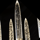 Luce di Roma Vesta chandelier glowing against a black background, highlighting gold framework and champagne crystal.