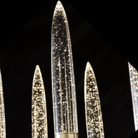 Luce di Roma Vesta chandelier glowing against a black background, highlighting gold framework and champagne crystal.