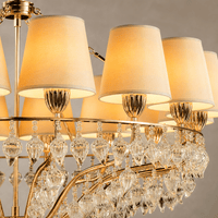 Close-up of Luce Regale Avorio Classica chandelier with ivory shades, gold frame and glass drops