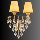 Gold chandelier with crystal accents and two gold lampshades on a dark background
