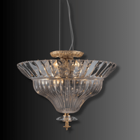 Luxury crystal pendant light with fluted glass and antique brass, warm ambient illumination on dark background