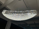 Installed 220 cm Lucerne Arc crystal chandelier illuminated, revealing its sweeping curved profile and layered prisms.
