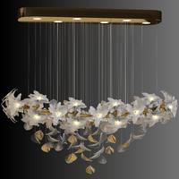 Magnolia Grazia chandelier with gold frame and white Murano-style glass blooms against a dark backdrop for dramatic contrast.