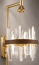 Close-up of the Manhattan Axis crystal wall sconce in gold finish with clear crystals and brown leather trim.