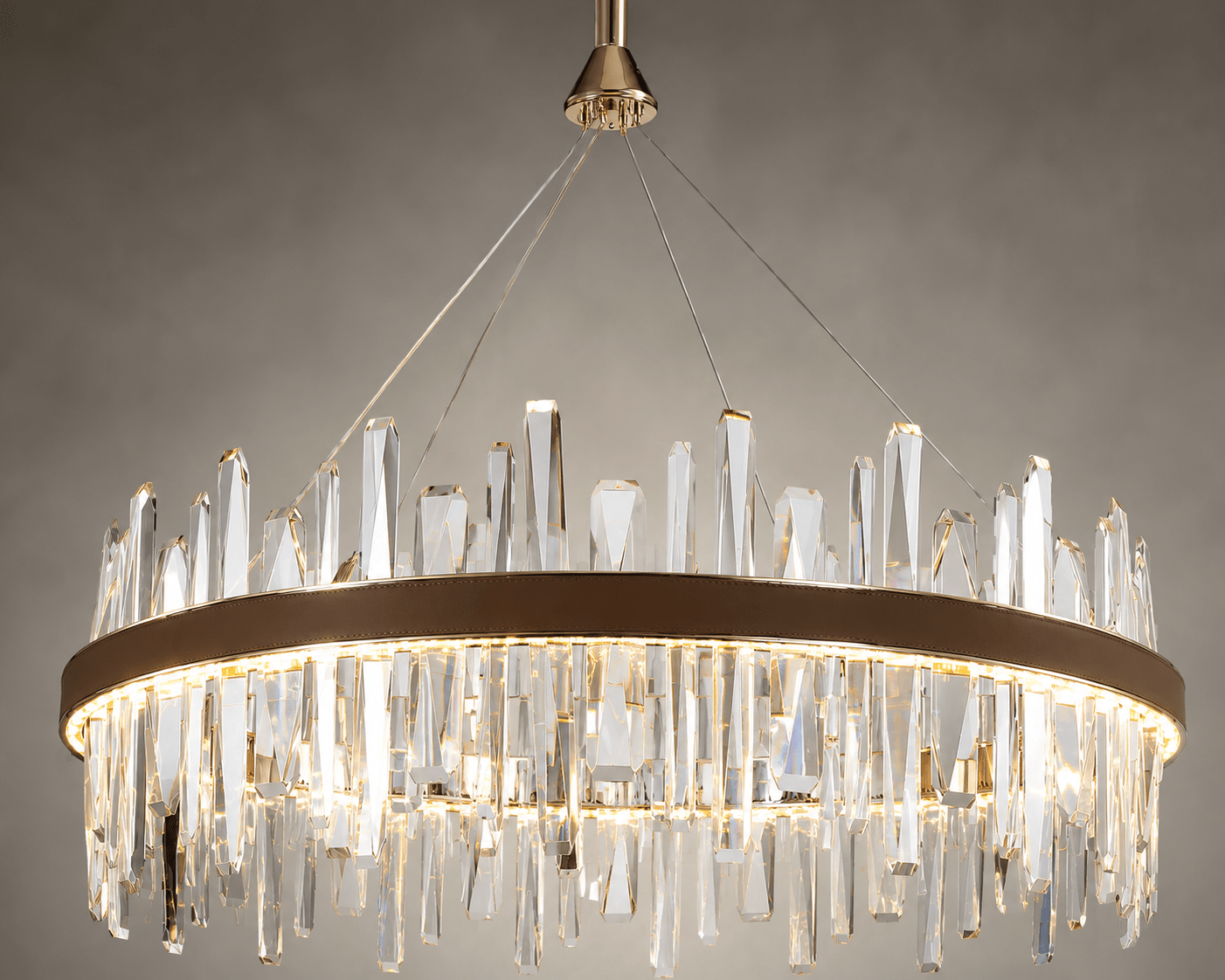Close-up of Manhattan Halo Crystal Chandelier with clear faceted crystals, leather band and warm gold light.