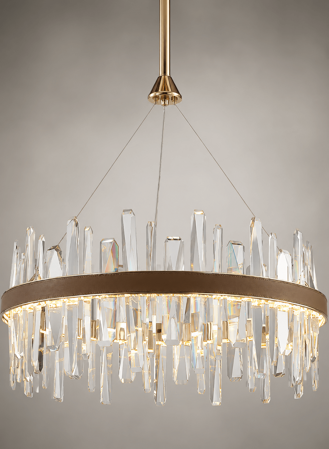 Close-up of the Manhattan Orbit Crystal Chandelier with clear crystal prisms, leather band and warm gold light.