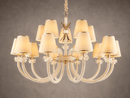 Close up of the Maria Grandeur 15-light chandelier with ivory shades and crystal-wrapped arms shown on a light grey background.