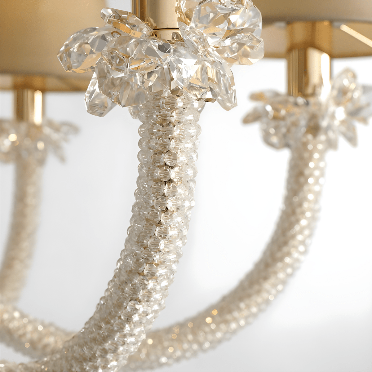 Close-up of Maria Grandeur chandelier showing precision-cut Asfour crystal detailing on curved arms and gold-plated copper.