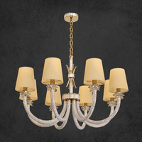 Hero image of the Maria Luxe 8-light chandelier with gold-plated frame, crystal-arms and ivory shades on a dark background.