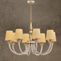 Maria Luxe 8-light gold crystal chandelier with ivory shades and Asfour crystal arms, shown against a grey wall background.