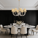 Maria Luxe chandelier hanging above a luxury dining table with cream chairs, with 8-light crystal and gold design.