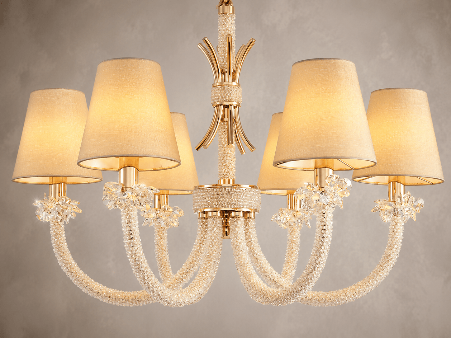 Close up shot of the Maria Petite Eclat showing the crystal, gold and fabric details against a light grey background.