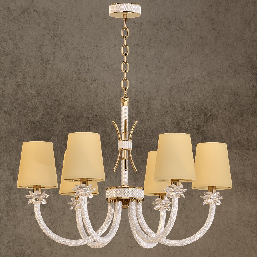 Maria Petite Éclat 6-light gold crystal chandelier with ivory shades and Asfour crystal arms shown a textured grey wall.