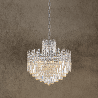 Maurice Argent crystal chandelier with stainless steel and Asfour crystals on a warm front view against a  beige backdrop.