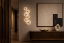 Modernus Amoria glass wall lamp illuminating a luxury hallway with warm neutral décor and contemporary art.