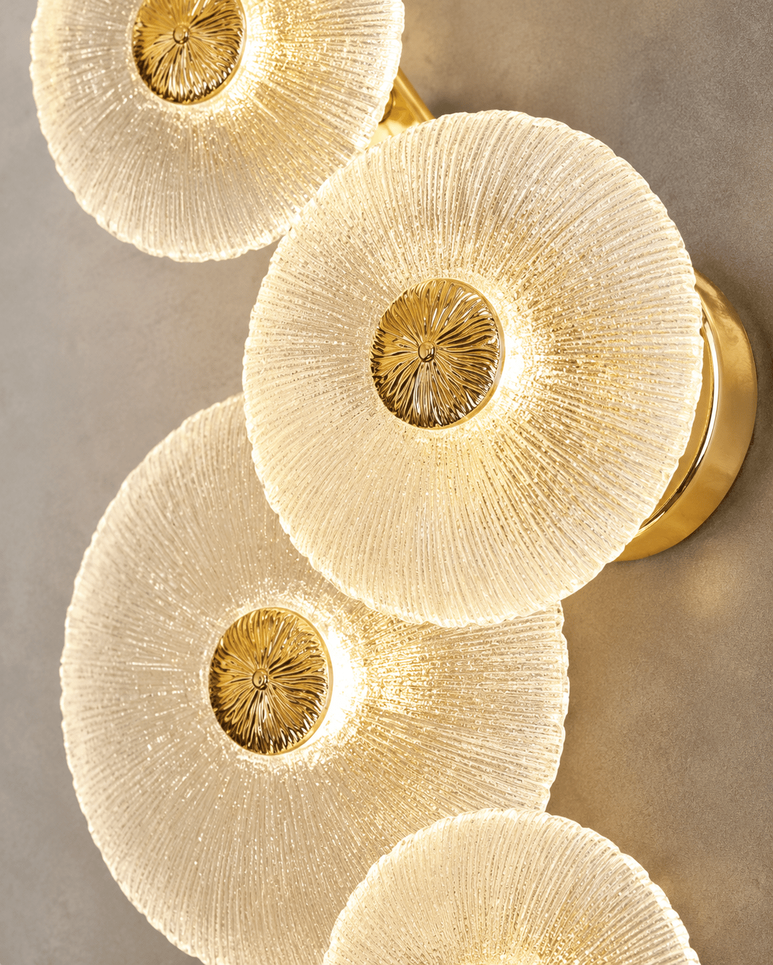 Close-up of Modernus Amoria Murano-style glass discs with ribbed texture, warm LED glow and gold centres.