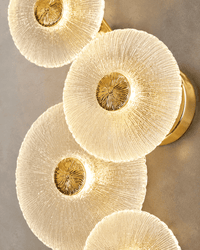 Close-up of Modernus Amoria Murano-style glass discs with ribbed texture, warm LED glow and gold centres.