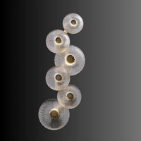 Modernus Amoria wall lamp displayed on dark background, showing sculpted Murano-style glass discs with warm LED.