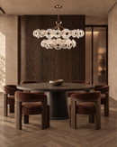 Modernus Halo art glass and copper chandelier by HDLS Lighting above a round table in a warm contemporary dining room.