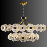 Side-angle view of the Modernus Halo chandelier showing sculptural Murano-style glass discs glowing on a dark background.