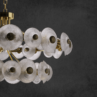 Close-up detail of Modernus Halo chandelier showcasing textured Murano-style glass discs and gold accents.
