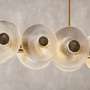 Close-up of Modernus Linear Murano-style glass chandelier with textured discs and brass finish by HDLS Lighting