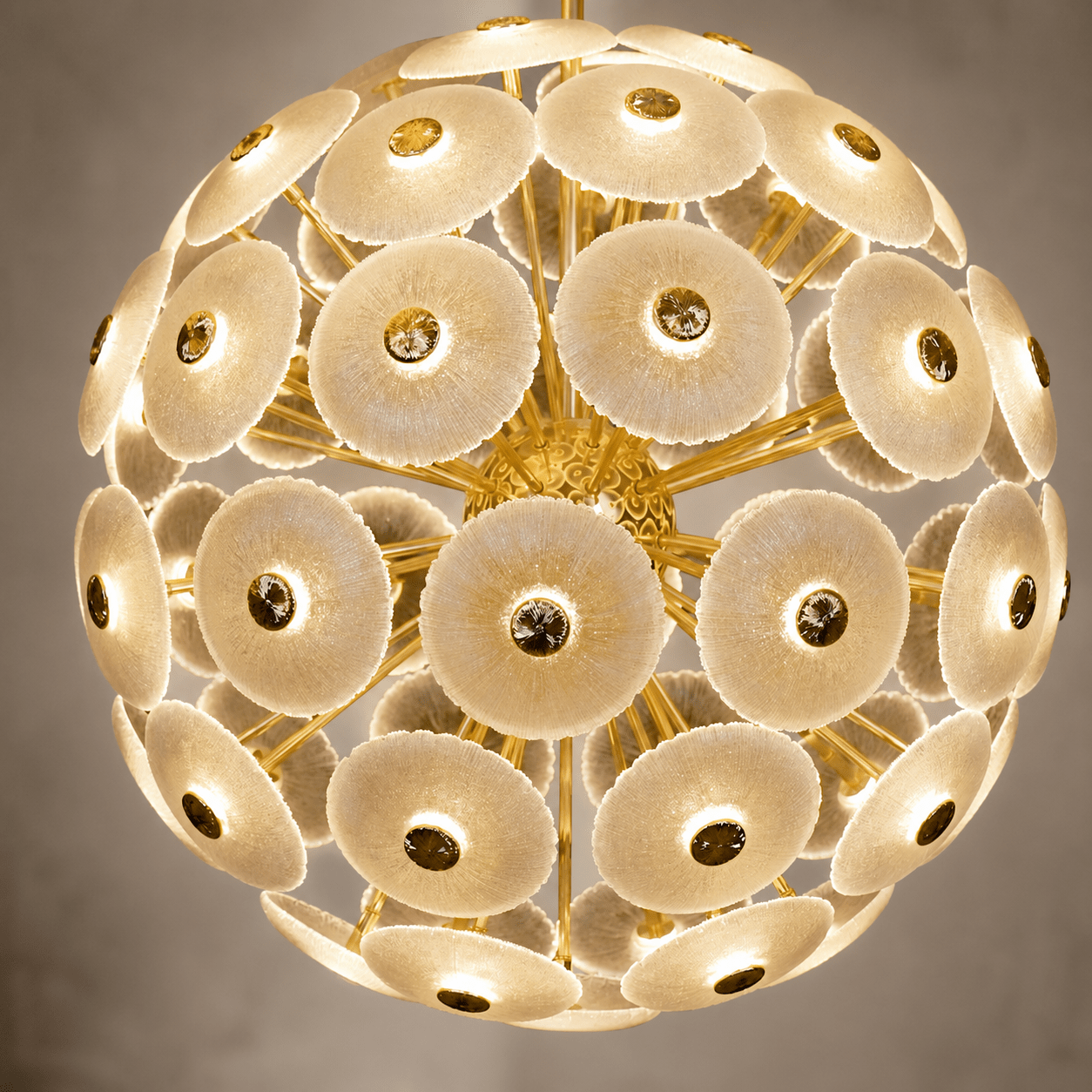 Close-up of illuminated Modernus Moon chandelier with textured Murano-style glass discs and gold frame.