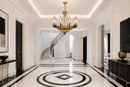 Opéra Noir Triomphe black and gold chandelier installed in a grand luxury foyer with sweeping staircase.
