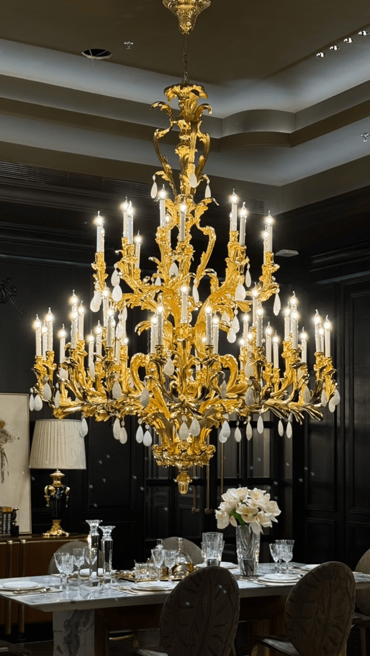 Palais Royal Grand Rococo Chandelier installed in a luxury dining room with 24K gold-plated copper and natural crystal.