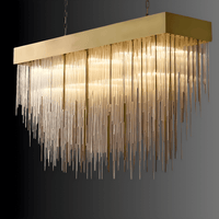 Angled view of the Petra rectangular chandelier featuring brass canopy and cascading architectural glass rods.