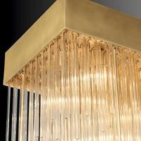 Suspended Petra rectangular chandelier in brass with cascading architectural glass rods, designed for modern interiors.