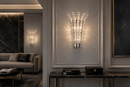 Plaza Crown Crystal Wall Sconce illuminating a luxury contemporary living room with polished chrome and crystal