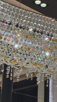 Close-up video of illuminated Asfour crystal and amber accents on the Aurelio Wave Oval chandelier.