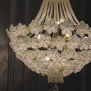 Close-up 15 second video of the Camellia Bloom chandelier showing glowing white glass flowers.