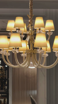 Maria Luxe chandelier showcasing gold-plated copper frame with Asfour crystal pearl and ambient lighting glow