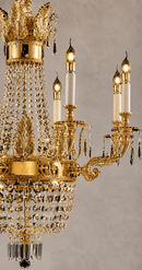 Close-up of Regency Noble gold chandelier with ornate copper arms, candle lights and Asfour crystal.