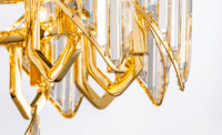 Close-up of Solaris Iris chandelier showing 18K gold-plated copper frame and precision-cut crystal elements