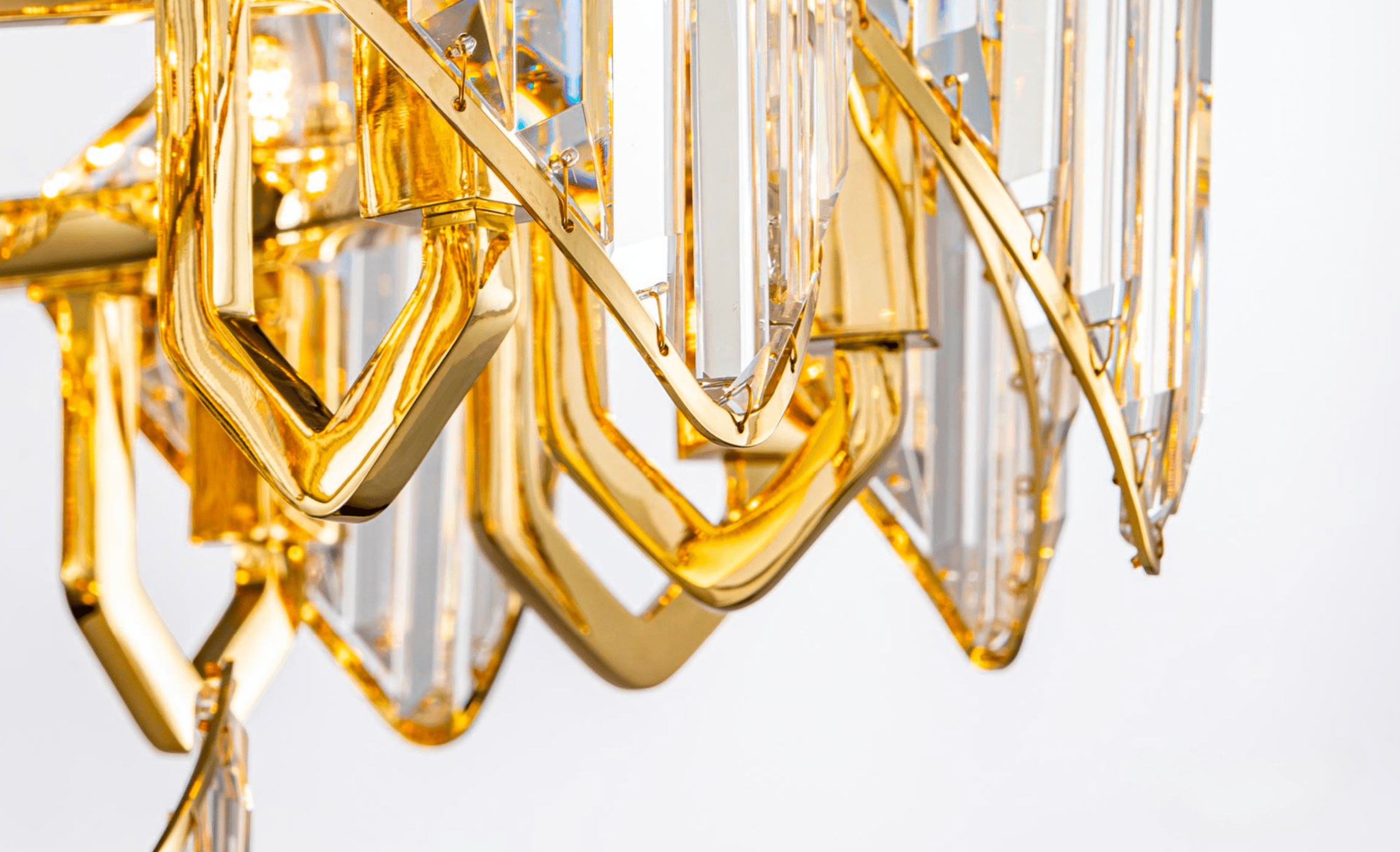 Close-up of Solaris Iris chandelier showing 18K gold-plated copper frame and precision-cut crystal elements