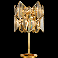 Solaris Lyra statement crystal table lamp in polished 18K gold-plated copper on black studio background.