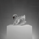 Limited-edition Swarovski crystal swan sculpture VAGHAAR displayed on pedestal with raised wings.